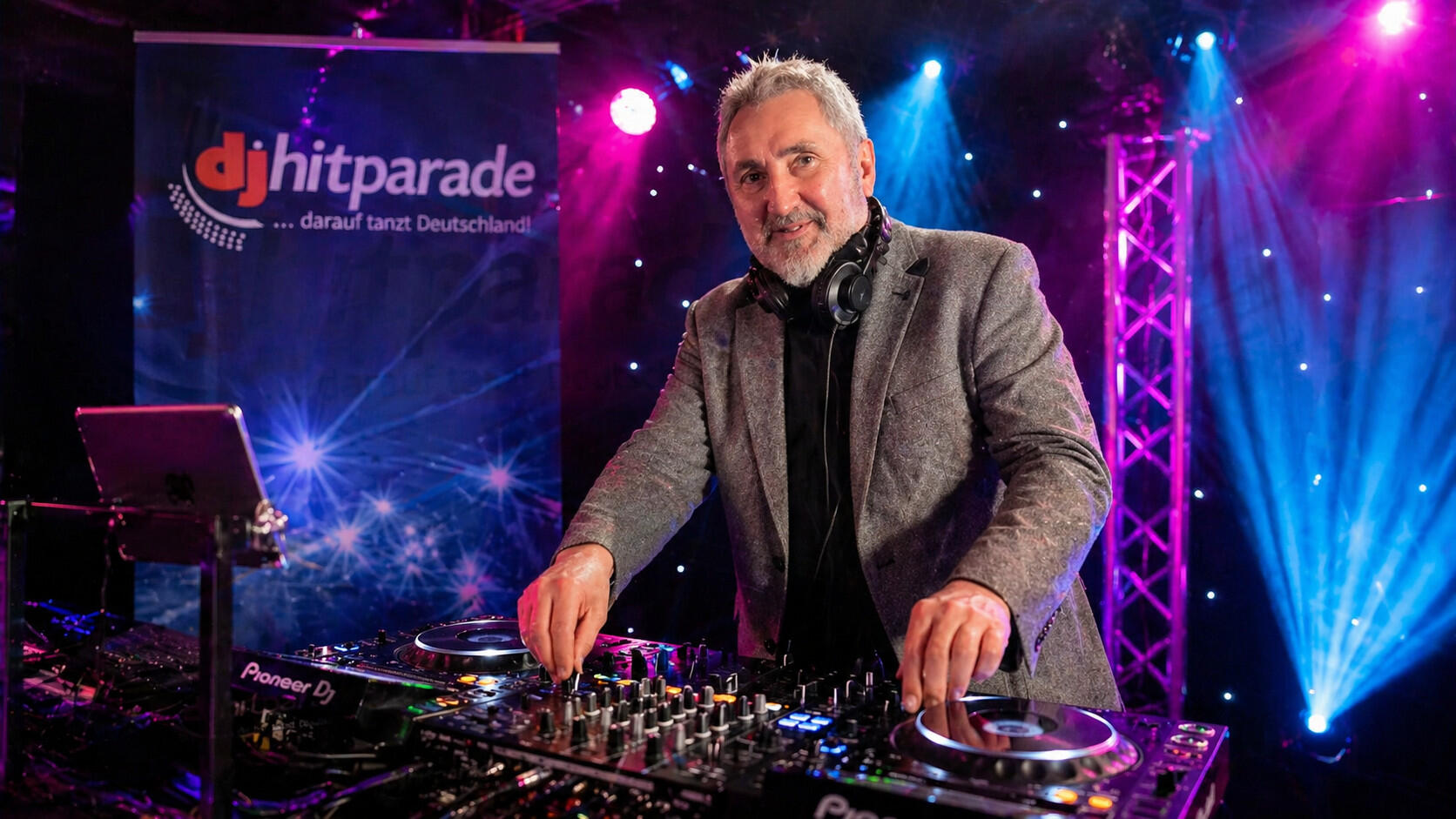 DJ im Nachtclub mit farbenfrohen Lichtern DJ im Nachtclub mit farbenfrohen Lichtern